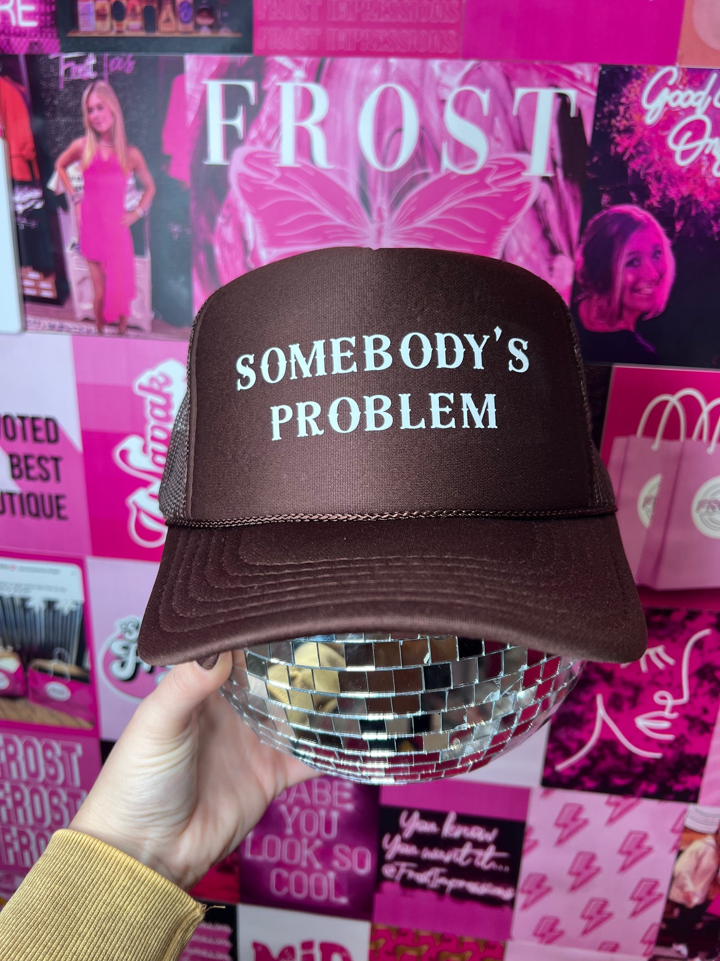 Dark brown foam Otto trucker hat with “Somebody’s Problem” design — trendy boutique hat from Frost Impressions Boutique in Wapakoneta, Ohio.