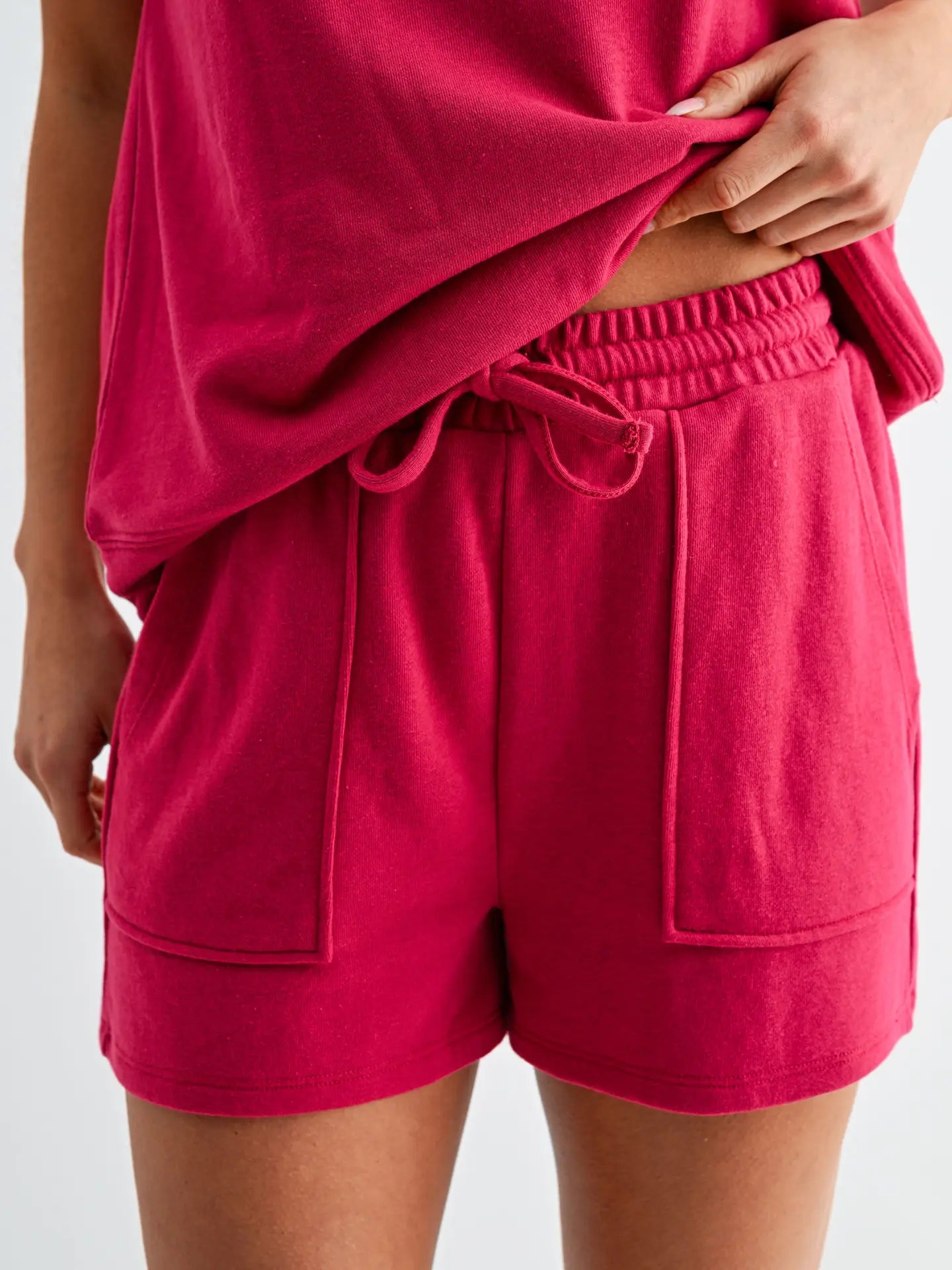Cranberry pink lounge set with cap sleeve top and matching shorts featuring elastic drawstring waistband and oversized pockets