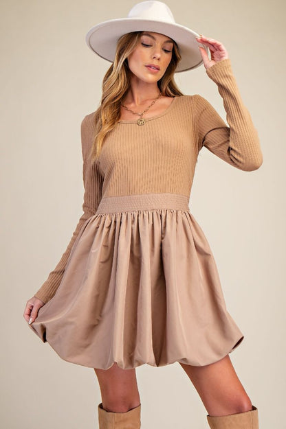 Camel Bubble Dress with bubble hem, ribbed knit bodice, wide scoop neckline, and side pockets.