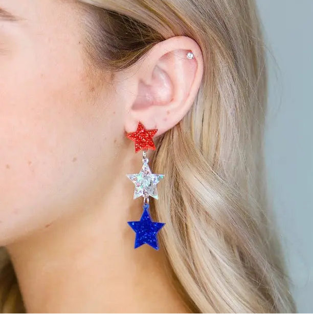 Star dangle earrings made of acrylic and alloy with gold finish and post-back closure