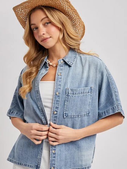 Medium wash short sleeve boxy denim button down shirt with relaxed oversized fit and chest pocket