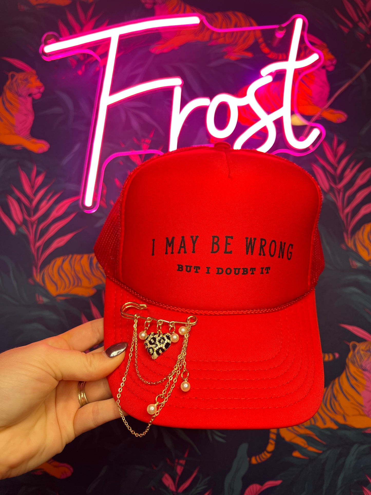 Red foam trucker hat with “I May Be Wrong But I Doubt It” phrase and optional leopard heart and pearl pin — boutique hat from Frost Impressions Boutique in Wapakoneta, Ohio.