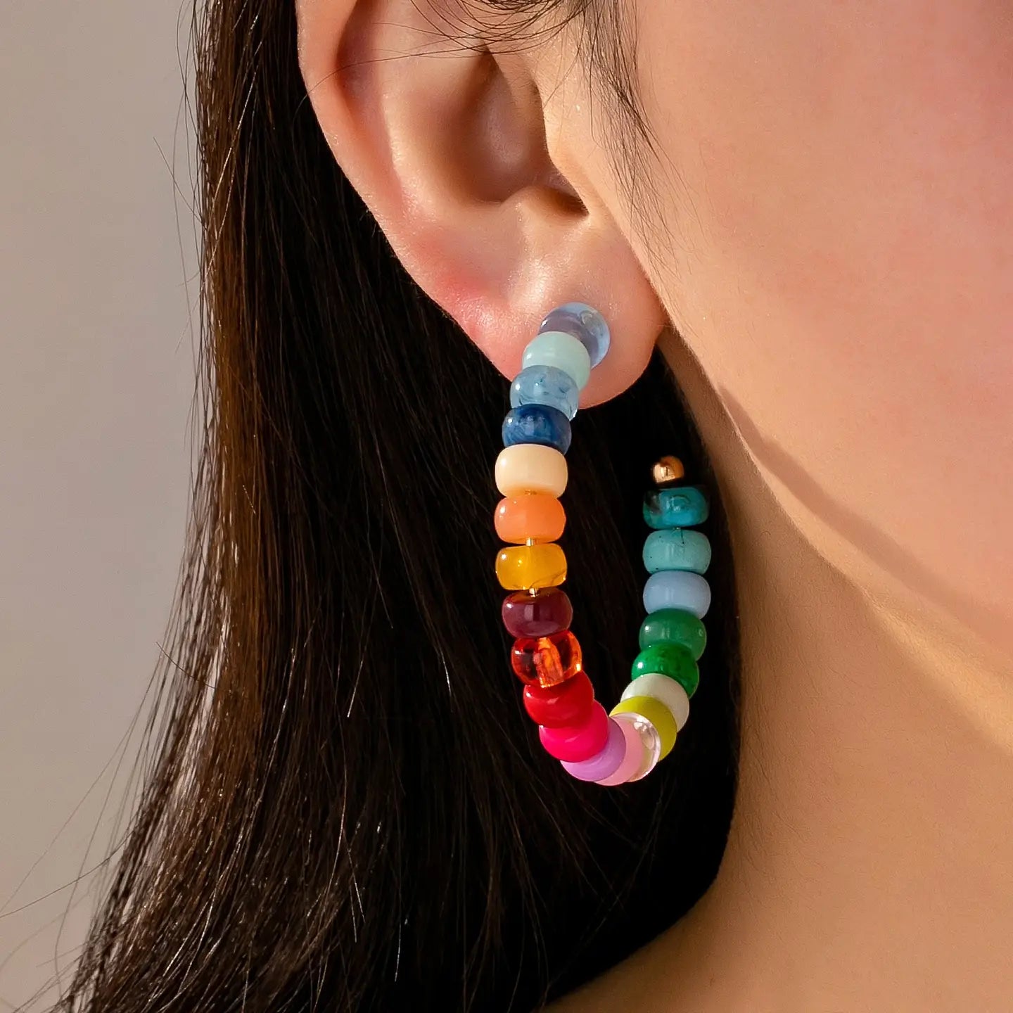 Multi-color resin beaded hoop earrings with bright rainbow tones and gold plated lightweight design