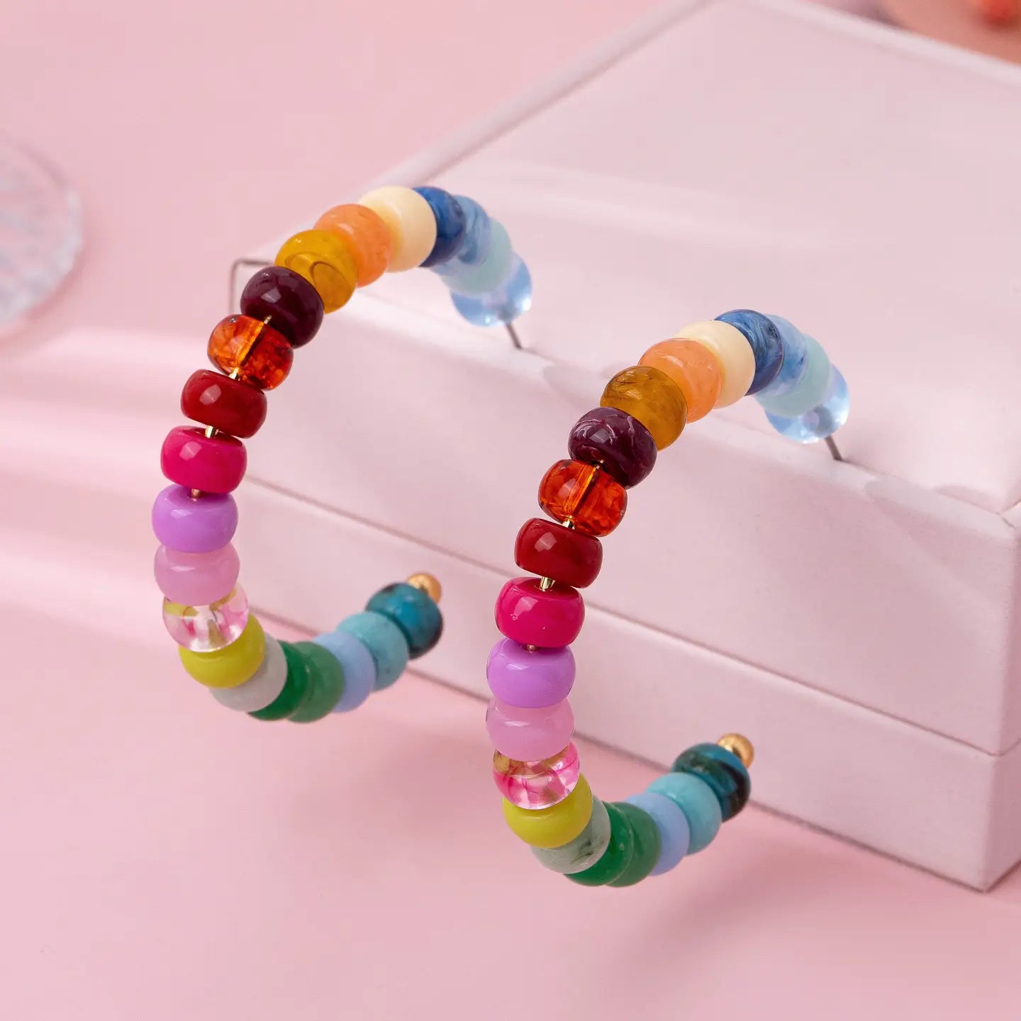 Multi-color resin beaded hoop earrings with bright rainbow tones and gold plated lightweight design