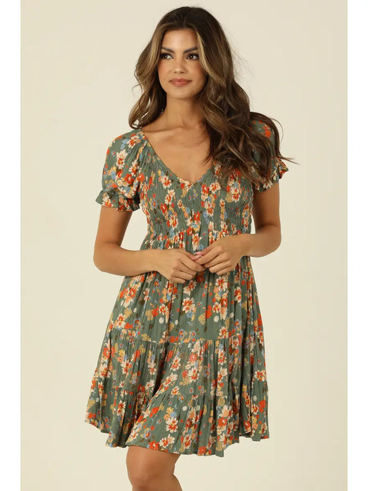 Green floral mini dress with smocked bodice, V-neckline, and short sleeves in a soft sage tone