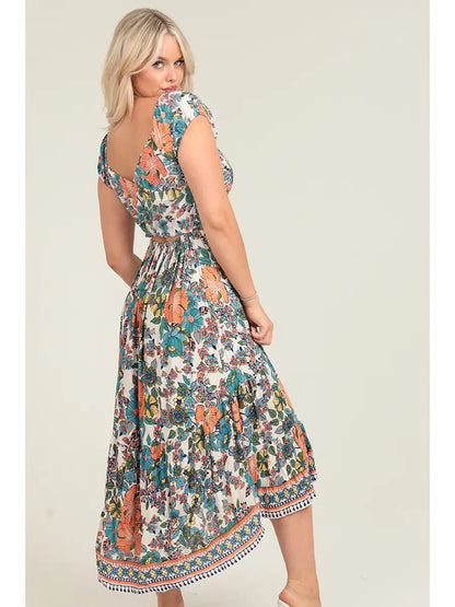 Floral smocked bodice maxi dress with crisscross back cutout detail and side slit in warm sunset tones