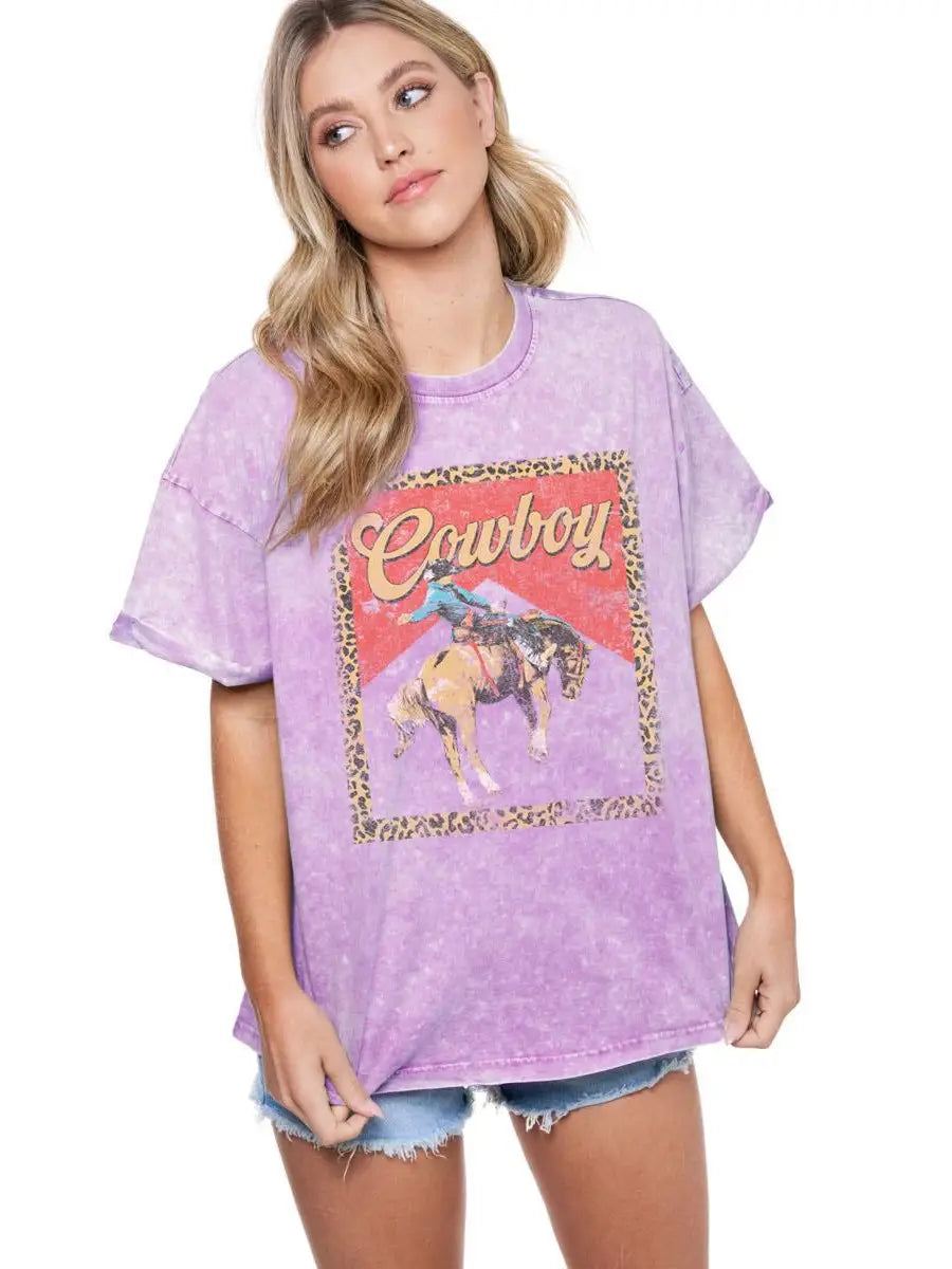 Lavender mineral washed graphic tee with vintage cowboy leopard frame design, rolled cuff sleeves, and boyfriend fit