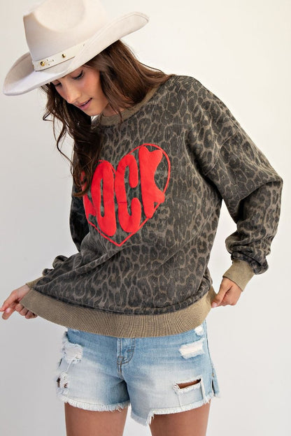 Wild at Heart leopard print mineral washed terry pullover with red “ROCK” heart graphic, oversized fit, and crew neckline.