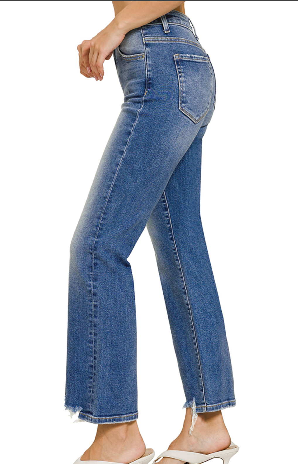 Stretch denim jeans with distressed frayed hem, cropped length, and medium wash finish